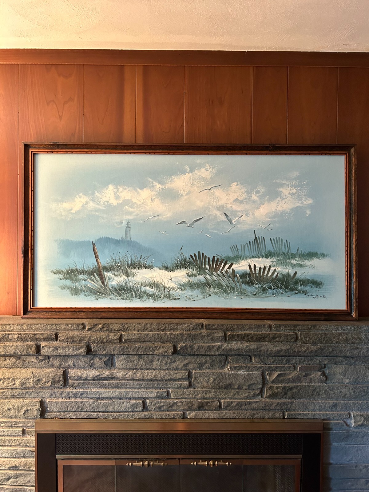 Beach view painting with a lighthouse fences and seagulls framed 26.5×51 in