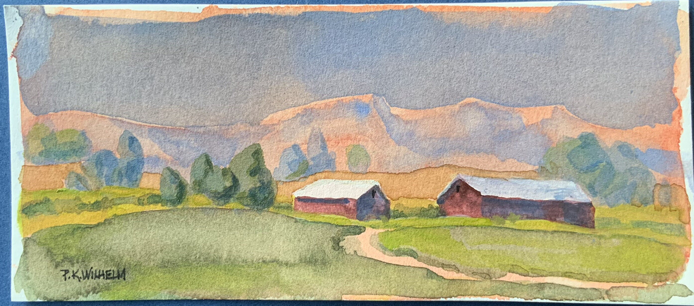 Pamela Wilhelm original 2.5×6” Watercolor Two Red Barns Mountain Hot Summer