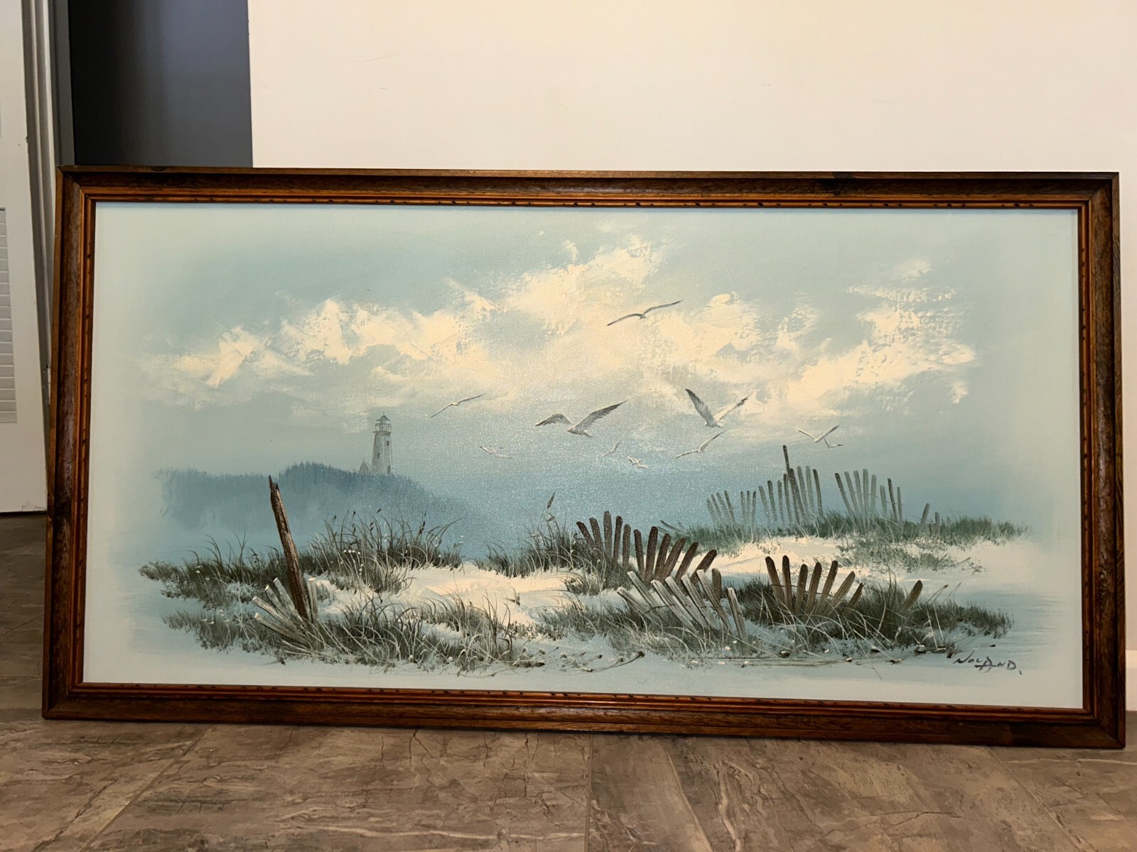 Beach view painting with a lighthouse fences and seagulls framed 26.5×51 in