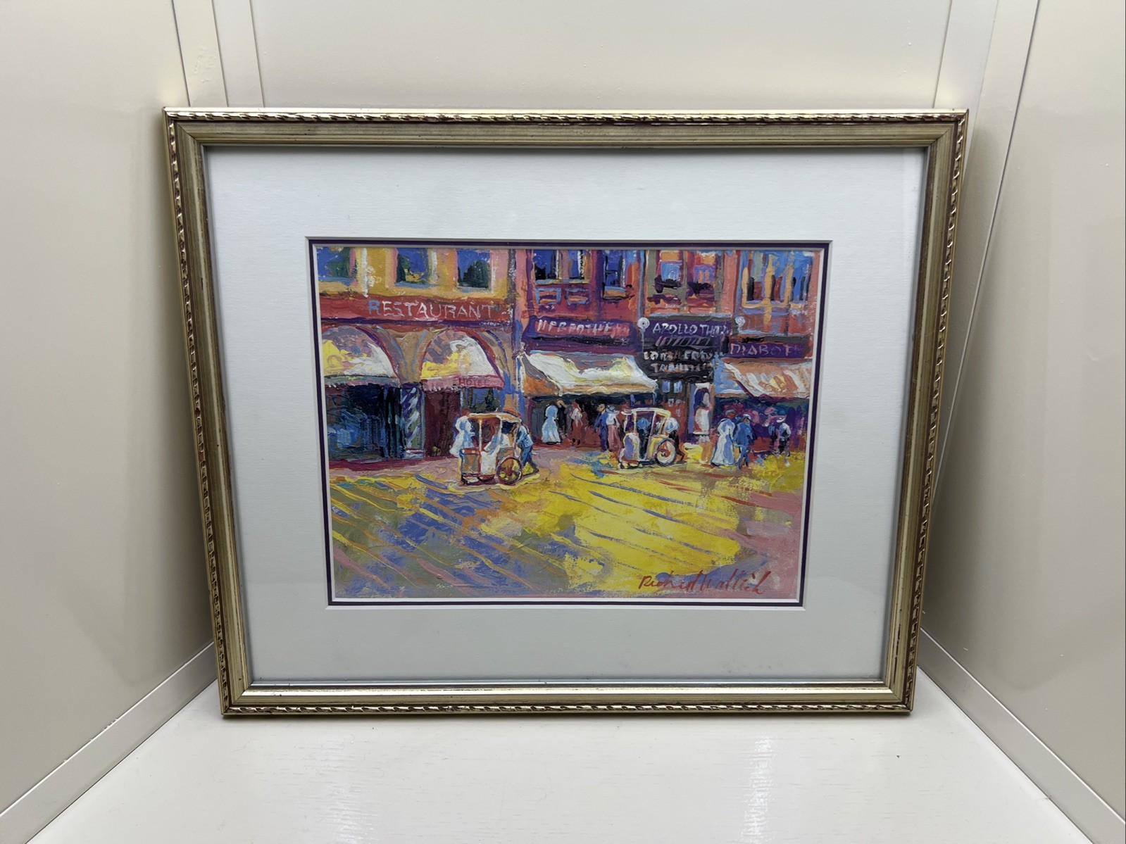 Framed painting of a street scene, signed by Richard Wallich, with a gold frame.